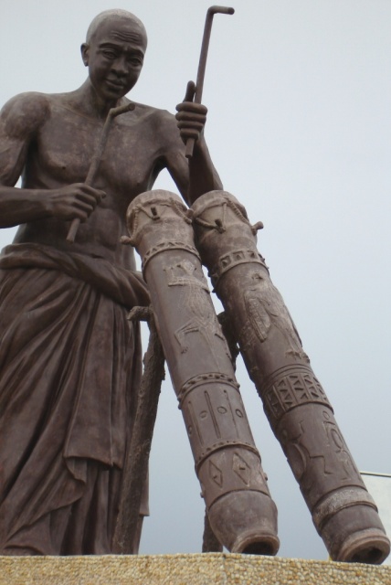 Statue representing an initiated man speaking the drum’s language and delivering a message.